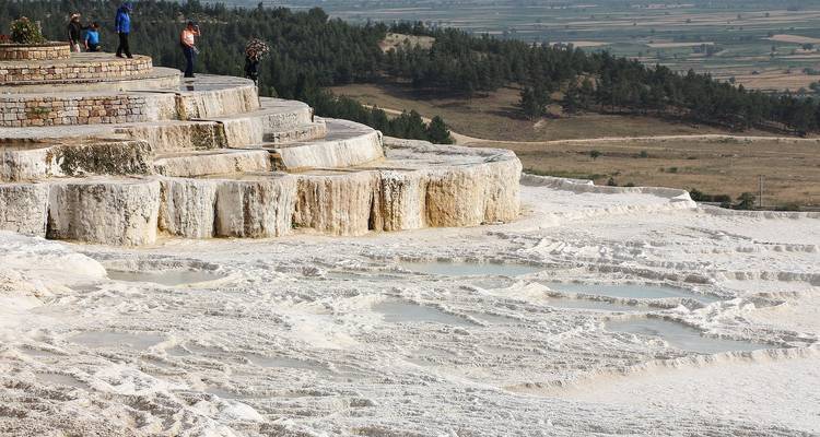 Piscinas minerales en terrazas de Pamukkale con turistas.