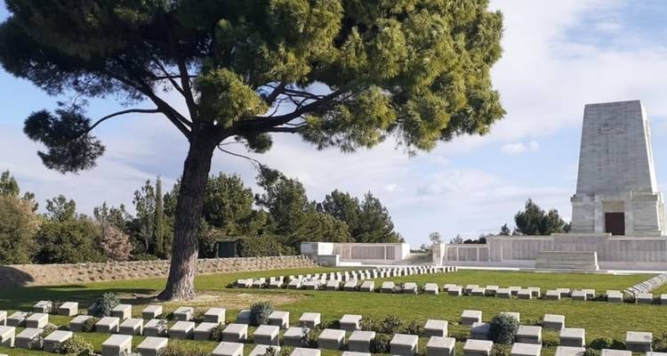 Memorial con filas de lápidas blancas en un cementerio bien cuidado.