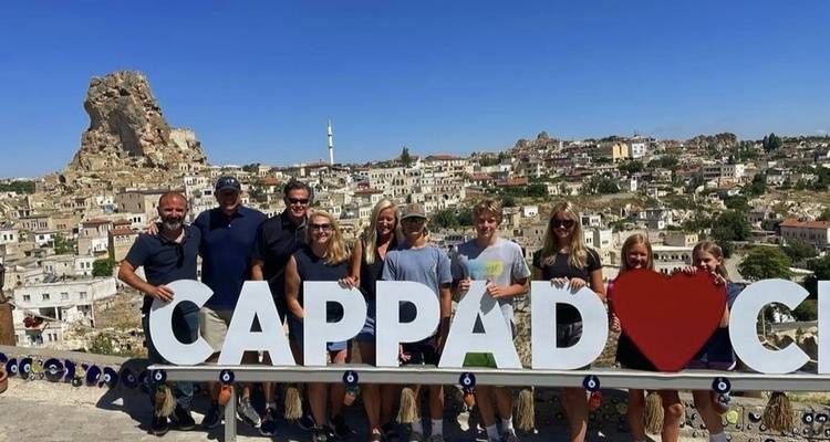Gruppe von Menschen, die mit einem „Kappadokien"-Schild posieren.