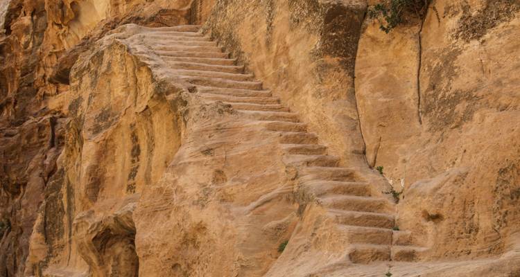 Anciens escaliers sculptés menant le long d'une paroi rocheuse escarpée.