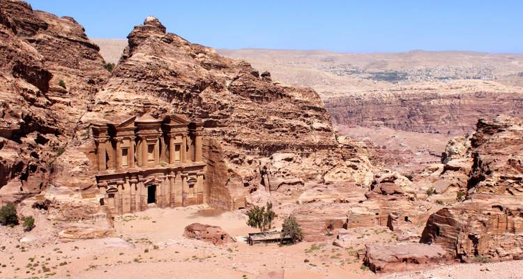 Vue lointaine du Monastère à Petra au milieu du terrain désertique.
