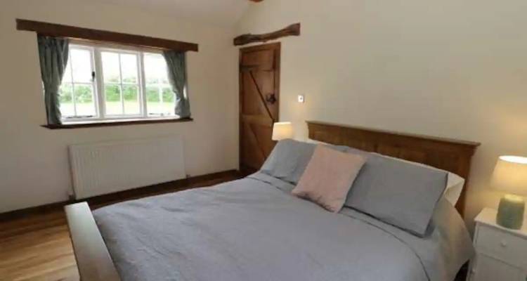 Interior of a cozy bedroom with a wooden double bed.