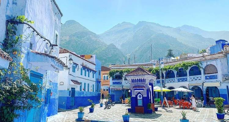 Carré coloré avec des bâtiments bleus et un paysage en arrière-plan.