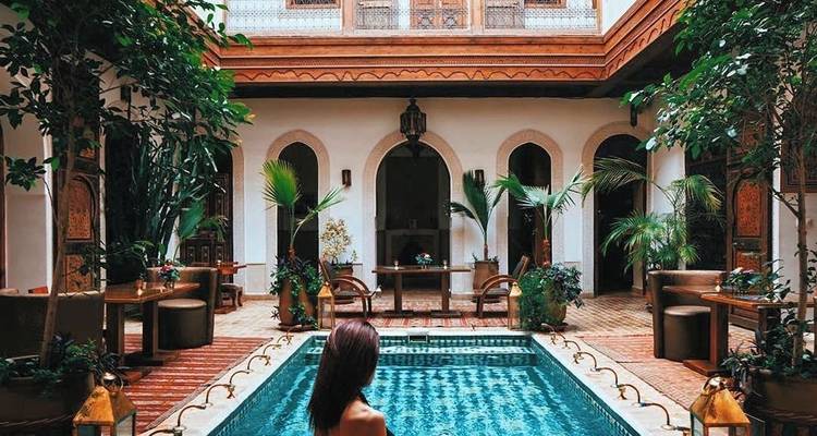 Piscine intérieure avec une femme assise au bord.