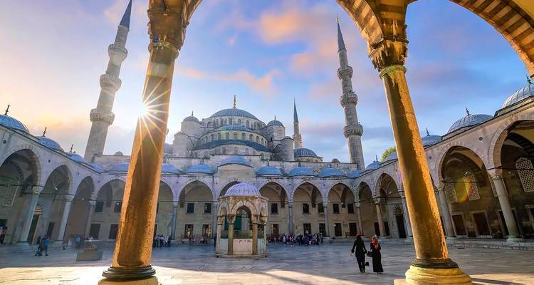 Courtyard view of a historic mosque at sunset.
