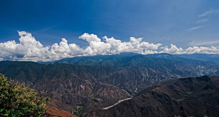 Mountainous landscape under a blue sky with white clouds.