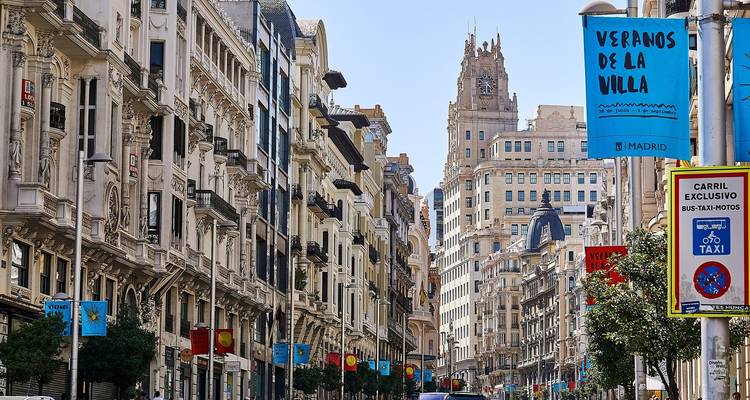 Street scene in Madrid with historical architecture and signs.