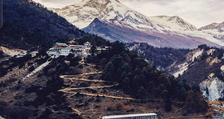 Bergdorp met kronkelende paden en bergachtige achtergrond.