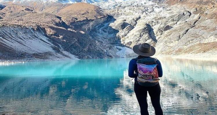 Reiziger bij een prachtig turquoise bergmeer.