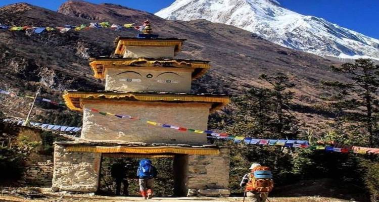 Boeddhistische stupa met gebedsvlaggen tegen Himalaya-toppen.