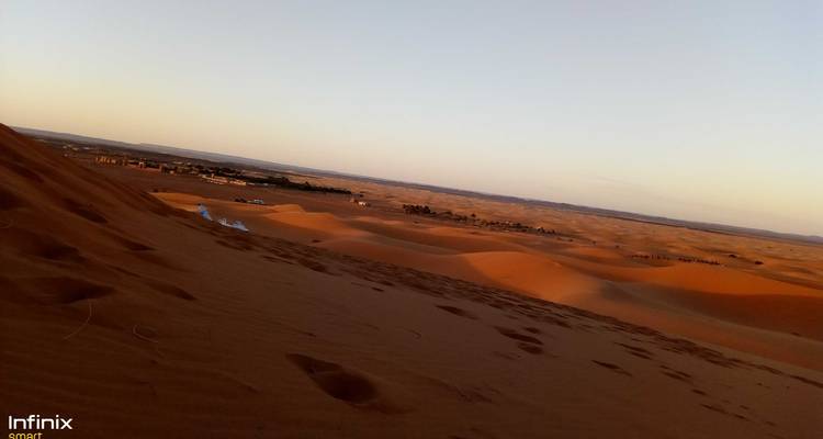 Woestijnlandschap met zandduinen bij zonsondergang.