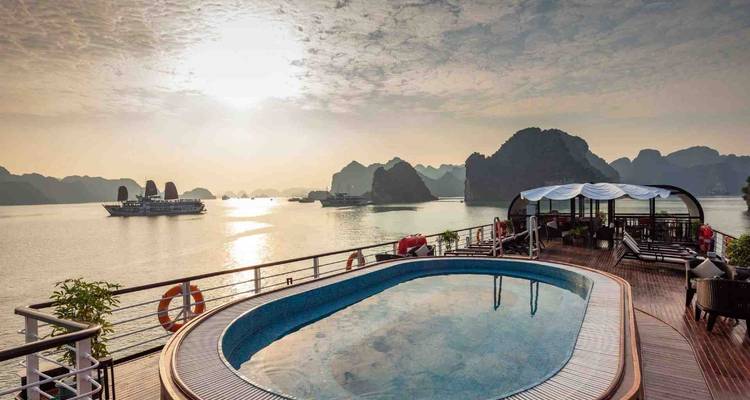 Luxurious deck with a pool overlooking the bay at sunset.