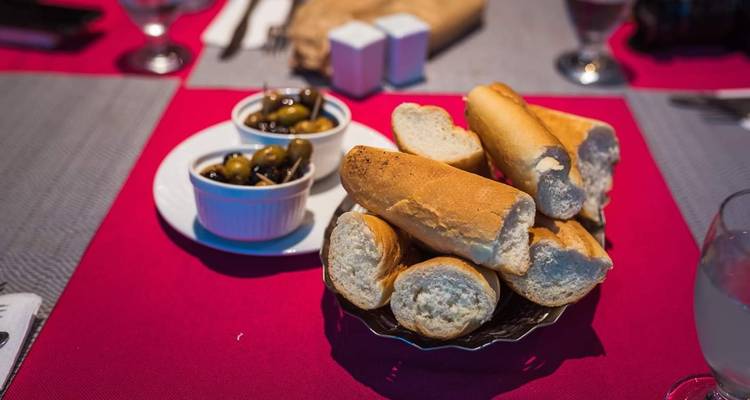 Du pain et des olives servis sur une table.