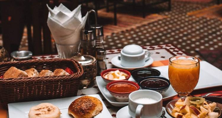 Petit-déjeuner avec viennoiseries, jus de fruits et café.