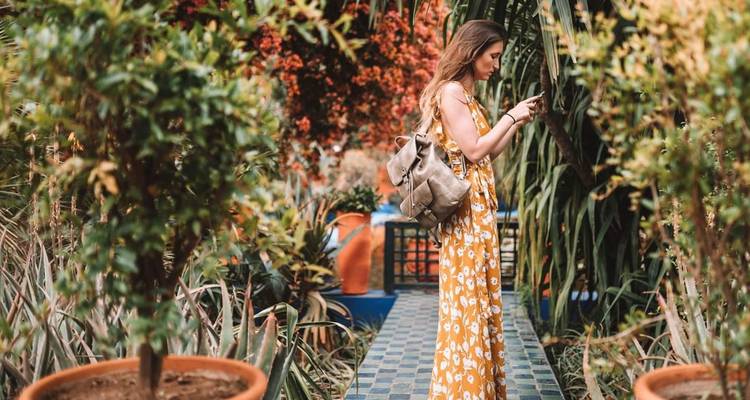 Vrouw in een tuin die een foto maakt met levendige planten.