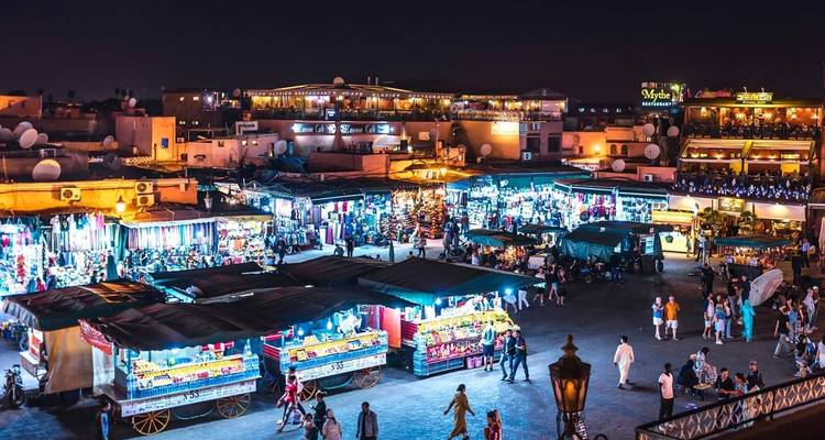 Levendige nachtmarktscène met lichten en winkelende mensen.