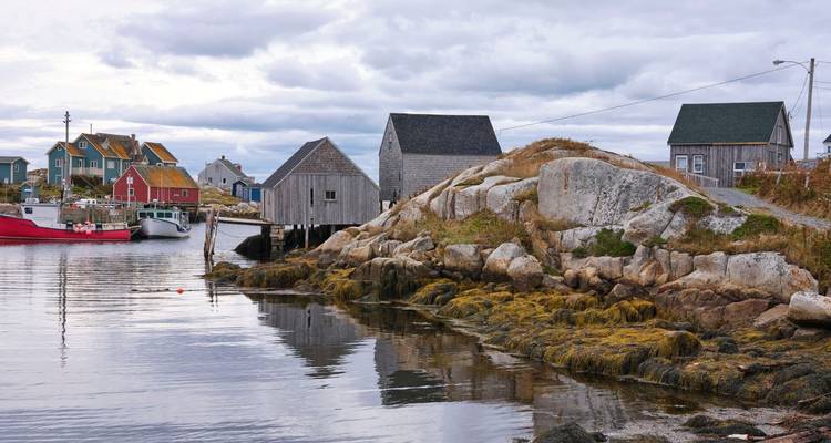 Vue pittoresque d'un petit village de pêcheurs avec des maisons colorées et des bateaux au bord de l'eau.