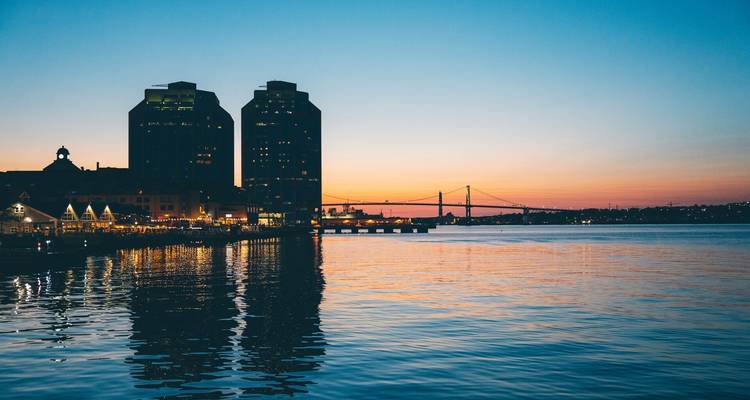 Horizon de Halifax au coucher du soleil avec un pont visible de l'autre côté de l'eau.