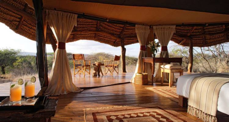 Luxe tent accommodatie met drankjes op een tafel.