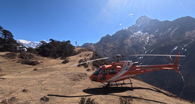 Helikopter geparkeerd op een berg met andere helikopters in de verte en een schilderachtig uitzicht.