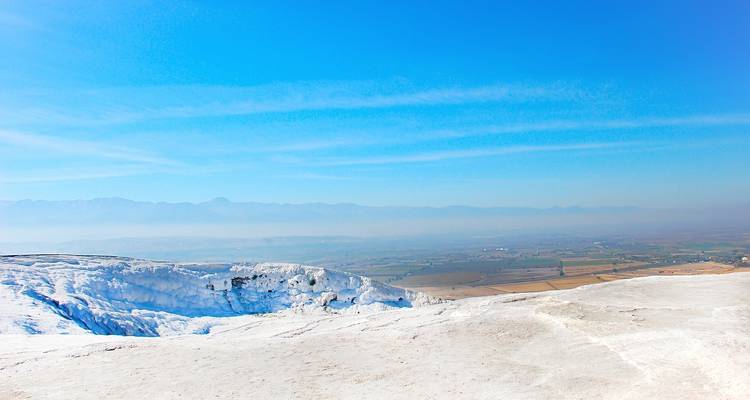 Travertijn terrassen in Pamukkale onder blauwe hemel.