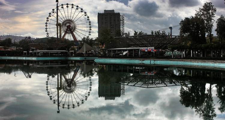 Reuzenrad reflectie in Ankara park met bewolkte lucht.