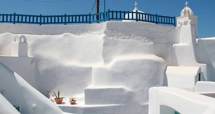 Witgekalkte gebouwen met blauwe accenten onder een heldere blauwe lucht.