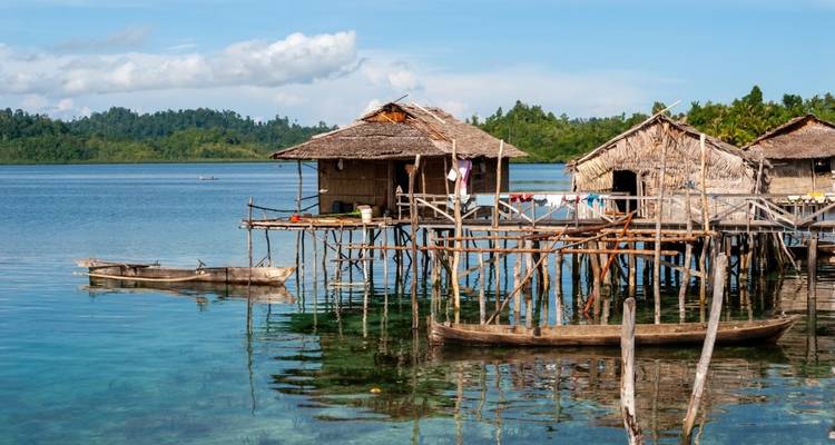 Traditionelle Pfahlbauten am klaren blauen Wasser.