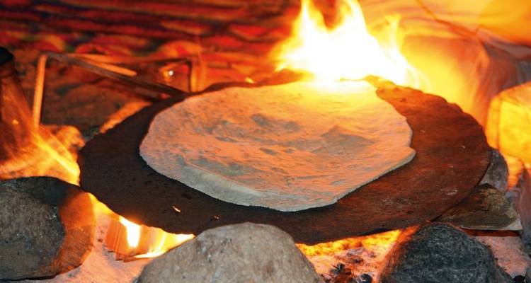 Fladenbrot wird über offenem Feuer gebacken.