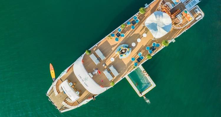 Luchtfoto van een cruiseschip dek met een zwemgedeelte en ligstoelen.