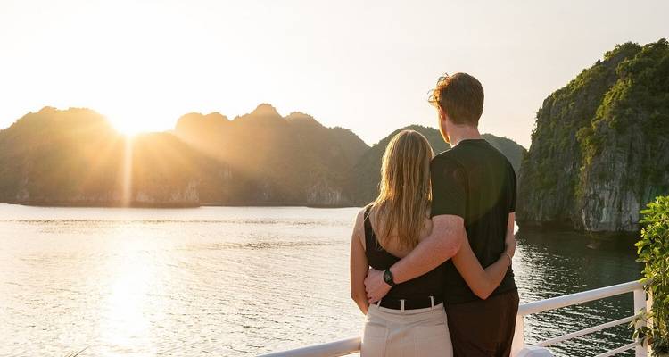 Stel dat elkaar omhelst bij zonsondergang met een schilderachtig uitzicht op de zee en eilanden.