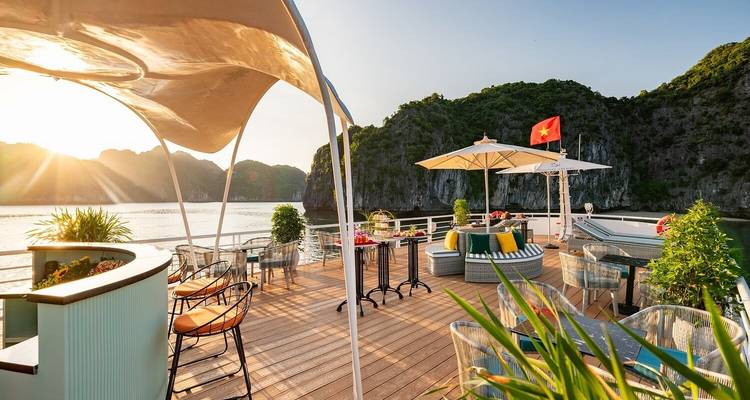 Dekgebied van een cruiseschip met vrij uitzicht op zee en zonsondergang.