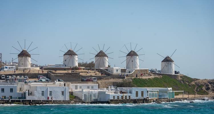 Rij traditionele windmolens op een heuvel aan zee.
