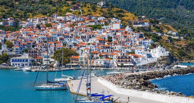 Charmant kustplaatsje met witte gebouwen en jachten afgemeerd in de haven.