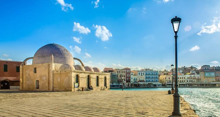 Bâtiment historique au bord de l'eau sous un ciel clair.