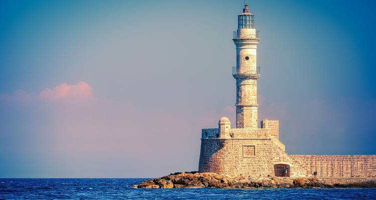 Phare sur une côte rocheuse avec un ciel dégagé.