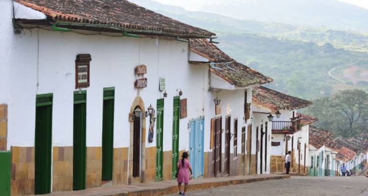 Una calle con edificios coloniales y una persona caminando.