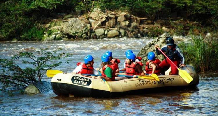Un grupo de personas haciendo rafting en aguas bravas en un río.