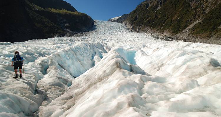 Randonneur sur glacier au milieu d'un vaste champ de glace en Nouvelle-Zélande.