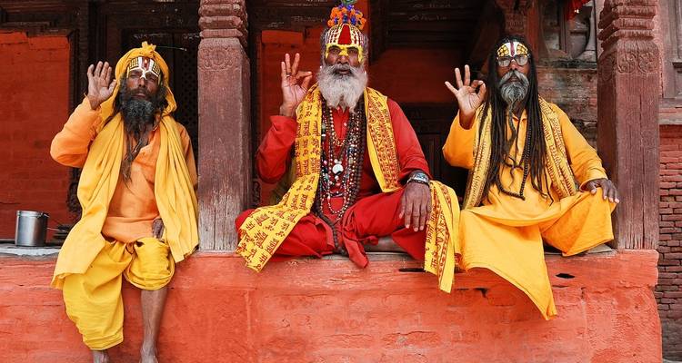 Trois sadhus en vêtements colorés qui posent.