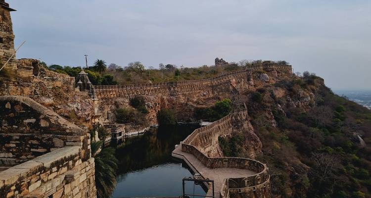 Historische Festungsmauern auf einem Hügel mit Blick auf den Fluss unten.