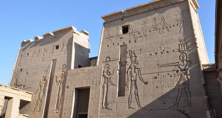 Murs de temple ornés d'hiéroglyphes et de sculptures anciennes.