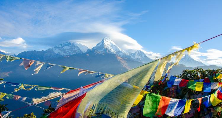 Vue des montagnes de l'Himalaya avec des drapeaux de prière colorés.