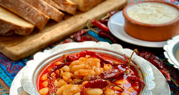 Bean stew with red chilies in ornate metal dish seen again.