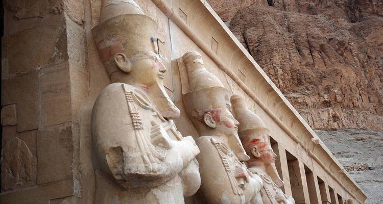 Oude beelden uitgehouwen in een stenen gevel.