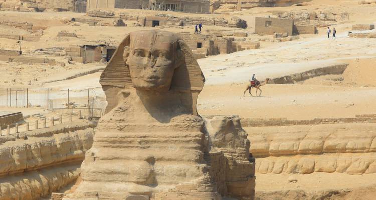 De Grote Sfinx van Gizeh met mensen en kamelen op de achtergrond.