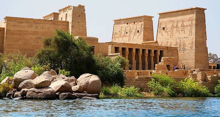 Tempelcomplex met oude zuilen en hiërogliefen aan het water.