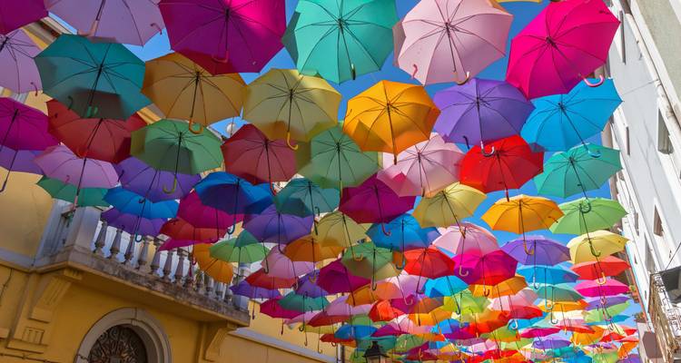 Des parapluies colorés suspendus au-dessus d'une rue.