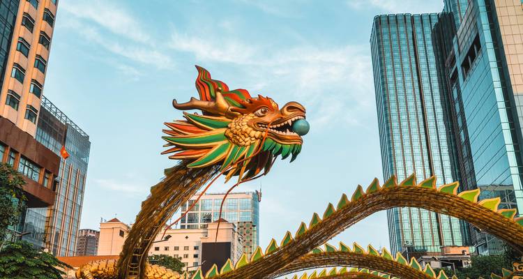 Dragon sculpture among tall buildings.