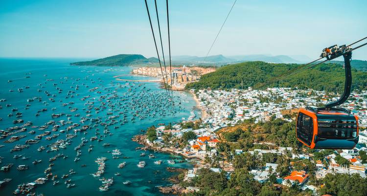 Aerial view of a bustling coastal city with cable car.